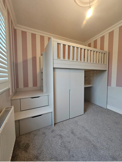Children's room with a white loft bed, desk, and storage drawers against striped walls.