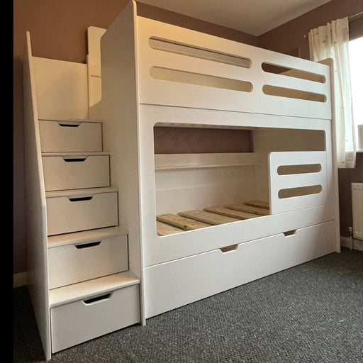 Space-saving white children's bunk bed combining sleeping area with extensive built-in drawer storage in the base and the staircase steps.