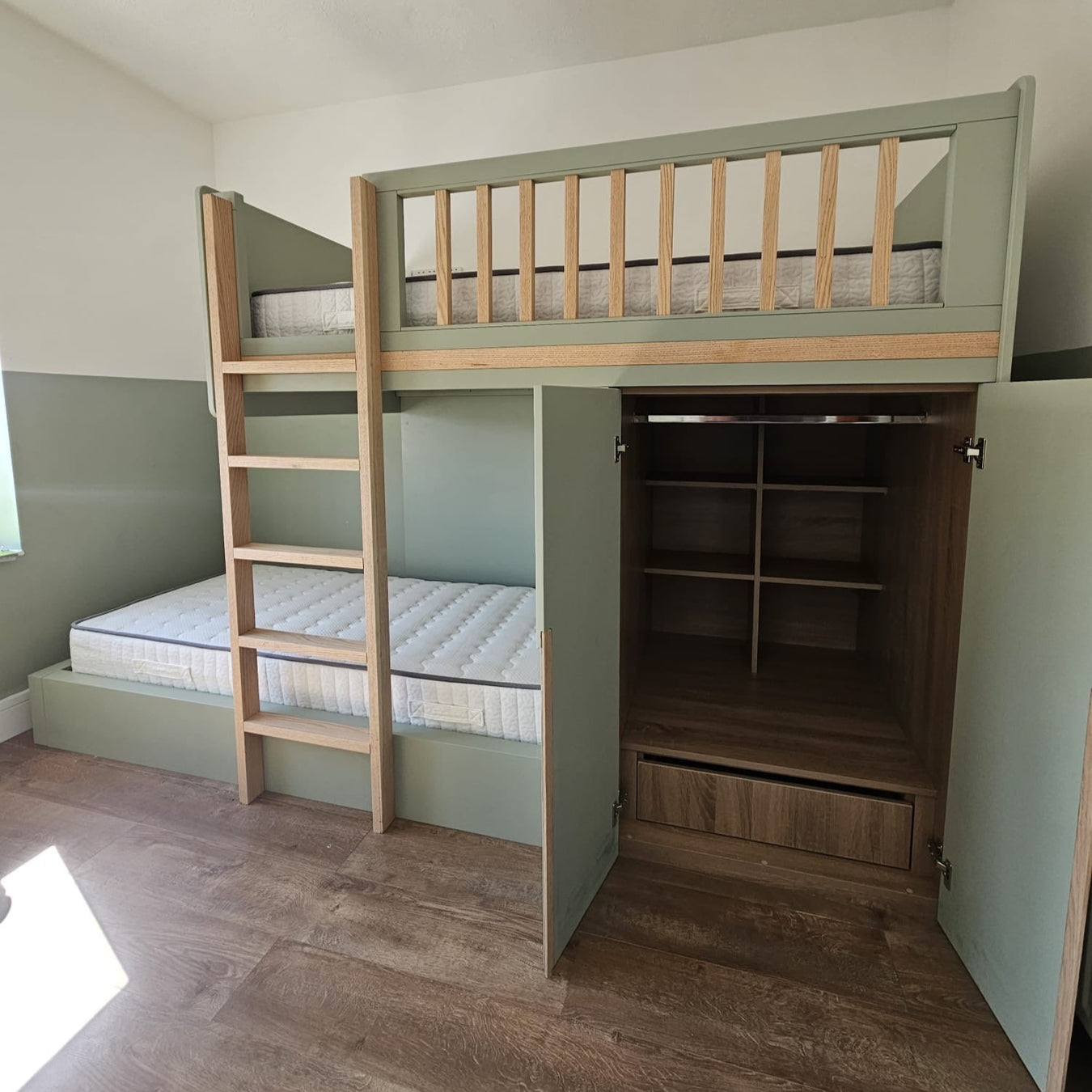 Wooden bunk bed with storage shelves in a room setting.