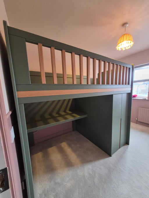 Green bunk bed with a striped desk in a room with a light fixture.