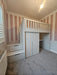 Children's room with a white loft bed, desk, and storage drawers against striped walls.